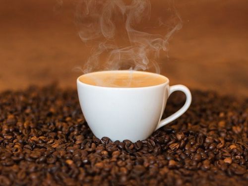 Кофейные зерна и чашка кофе с молоком