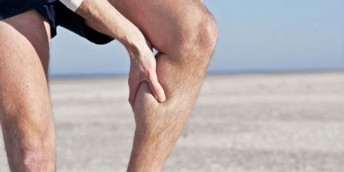 Мужчина держится рукой за ногу
